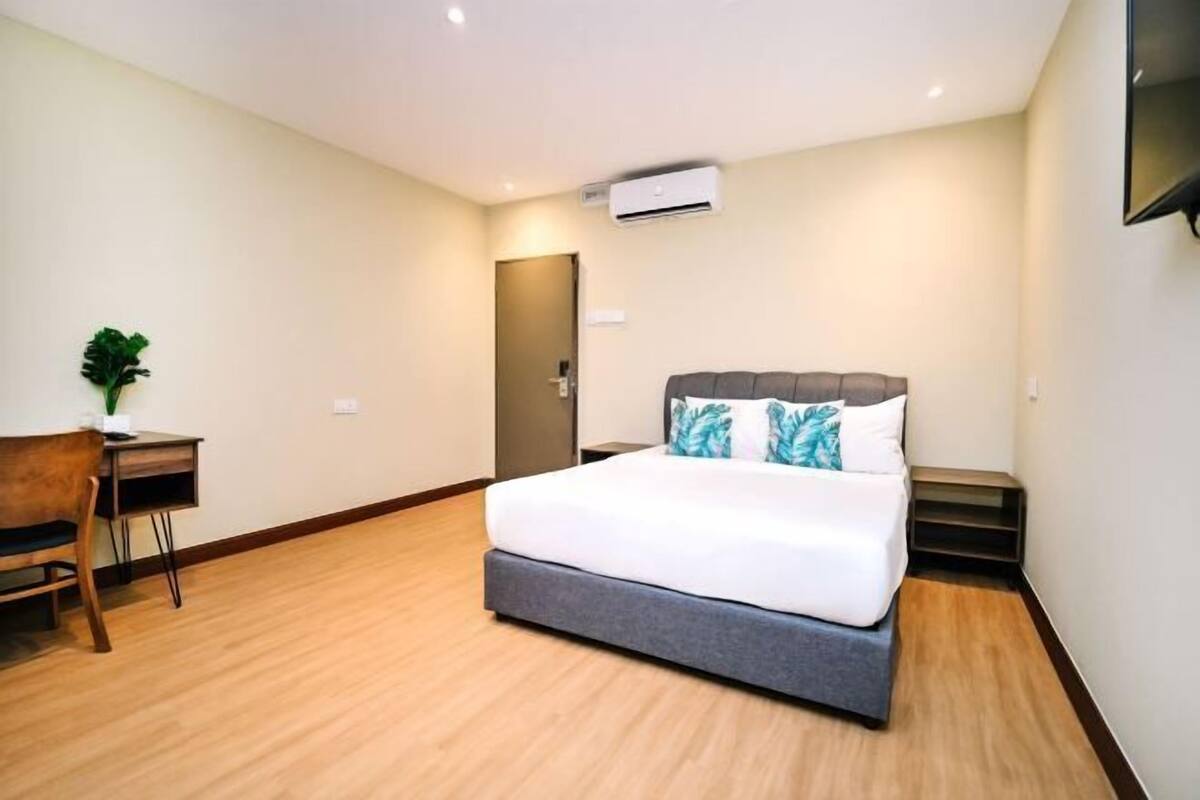 A hotel room with a bed, a desk, and a chair.