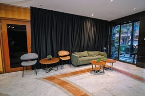 A modern living room with a sofa, two armchairs, and two coffee tables. - Kingston Hotel 6 @ Changkat Bukit Bintang (Kuala Lumpur)