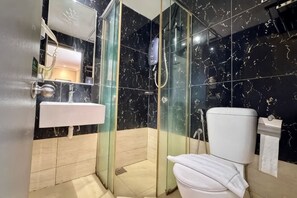 A bathroom with a glass-enclosed shower, a white sink, and a toilet. - Kingston Hotel 6 @ Changkat Bukit Bintang (Kuala Lumpur)