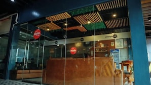 A modern interior with a reception desk, glass walls, and a patterned floor. - CITISTYLE INN (Davao)
