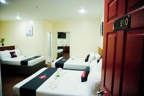 A hotel room with two beds, a TV, a desk, and a door with the number 210. - CITISTYLE INN (Davao)