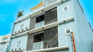 A multi-story building with a balcony on the second floor and a large window on the third floor. - CITISTYLE INN (Davao)