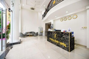 A hotel reception area with a marble counter, a staircase, and a seating area. - The Shilla Luxury I Hotel-더신라럭셔리호텔 (Ho Chi Minh City)