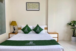 A hotel room with a bed, two pillows, a nightstand, a lamp, and a potted plant. - The Shilla Luxury I Hotel-더신라럭셔리호텔 (Ho Chi Minh City)