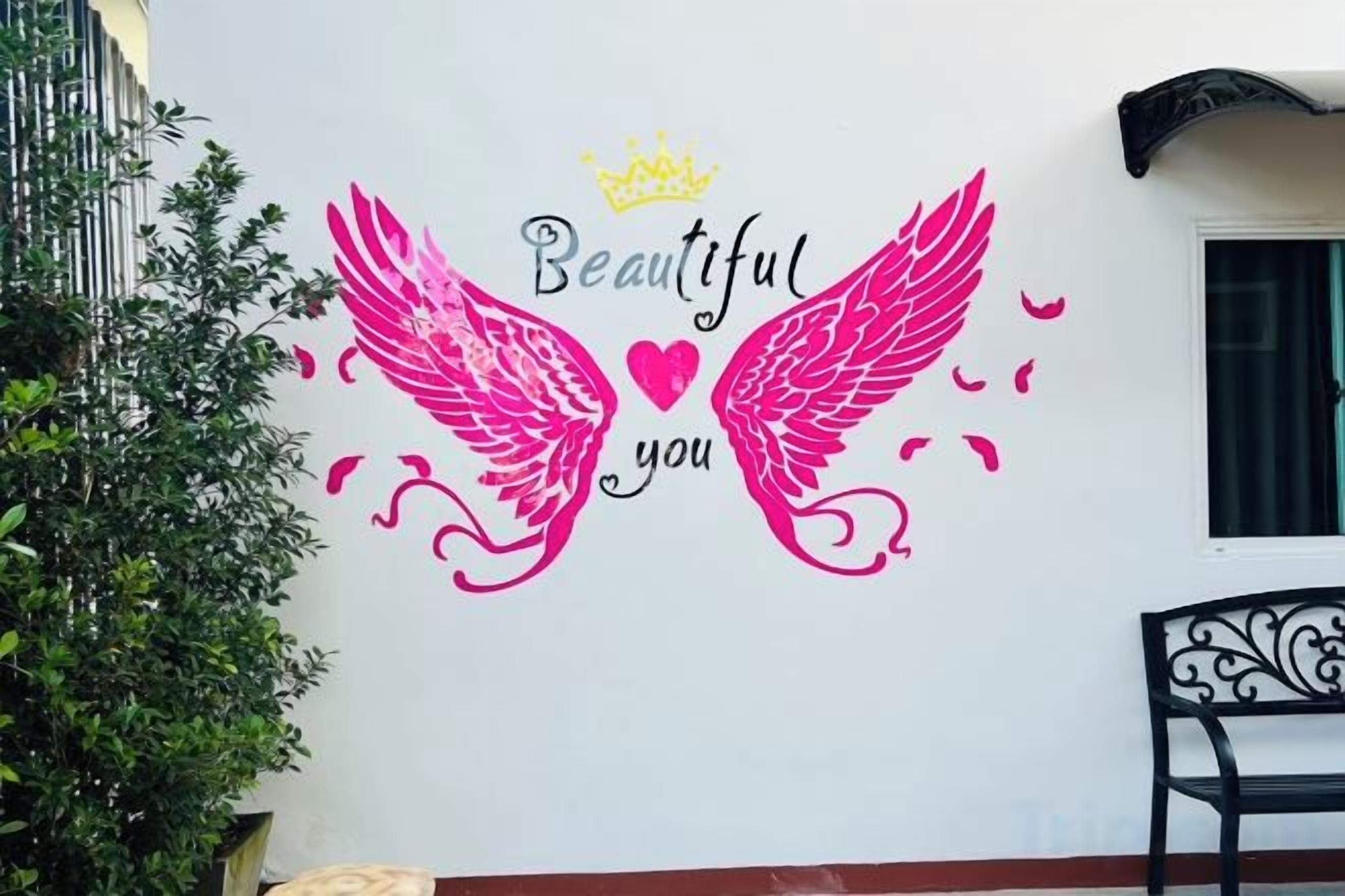 A wall with a decorative phrase 'Beautiful you' and a crown symbol.