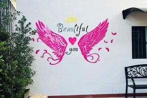 A wall with a decorative phrase 'Beautiful you' and a crown symbol. - V RICH (Roi Et)