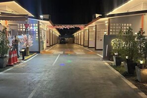 Un couloir d’hôtel avec un sol mouillé, des plantes en pot et une personne debout près d’une porte.