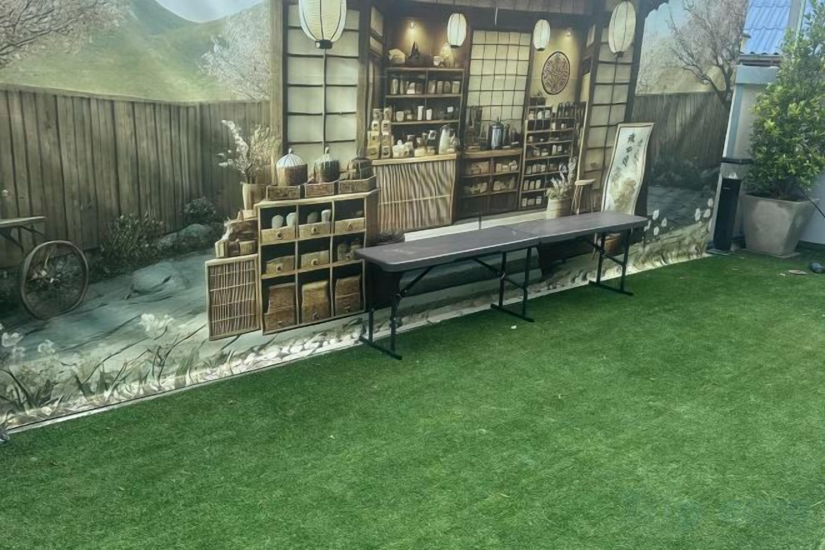 A backyard with a wooden fence, a table, and a bench.