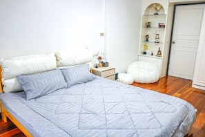 Une chambre à coucher avec un lit, une table de chevet et une armoire.