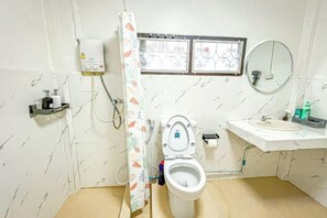 A bathroom with a toilet, sink, shower curtain, and a window with decorative glass. - Luck viia 2 (Bangkok)