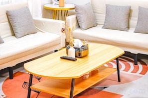 Un salon moderne comprenant un canapé, une table basse et une petite table d’appoint.