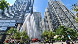 A high-rise building with a water feature in front.