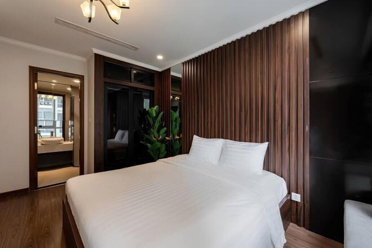 Habitació d'hotel moderna amb un llit gran, panells de fusta i vistes a la ciutat.