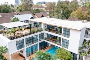 A modern multi-story building with a rooftop pool and outdoor seating areas. - Alden Design Pool Villa (Pattaya)