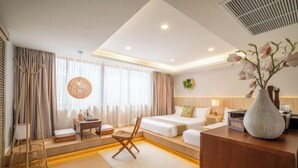A hotel room with a bed, bedside table, chair, and a decorative vase. - Alden Design Pool Villa (Pattaya)