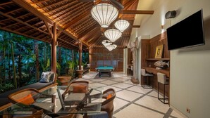A spacious indoor area with a pool table, seating, and a television.