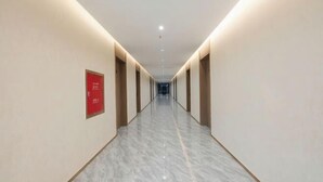 A long, narrow hallway with a polished marble floor and recessed lighting. - New Junlong Hotel (Bavet)