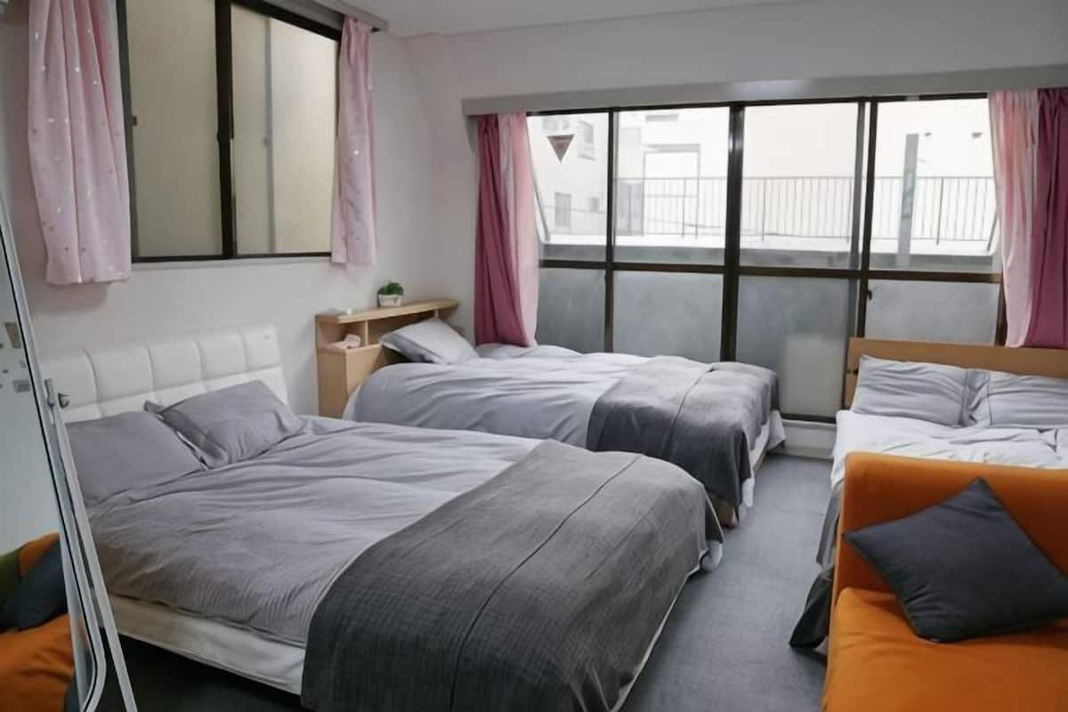 Ein Hotelzimmer mit zwei Betten, einem Fenster und Blick auf die Stadt.