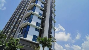 A high-rise building with multiple balconies and windows, surrounded by palm trees. - C2011 Almas Suites Studio Netflix Johor by STAY (Iskandar Puteri)