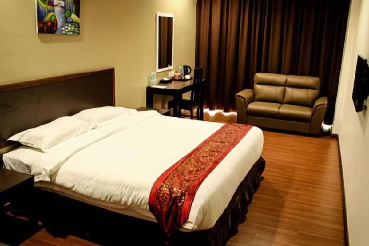 Une chambre d’hôtel avec un grand lit, un bureau, une chaise et un canapé.