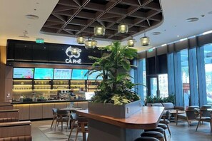 A modern interior with a bar area, seating, and large windows. - A La Carte Ha Long Bay Apartments by Kevin & Anna (Ha Long)