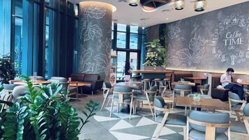 Ein modernes Café-Interieur mit Sitzgelegenheiten, einem großen Fenster und einer Wand zum Thema Kaffee.