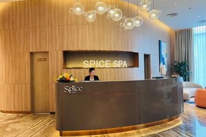 Un comptoir d’accueil portant l’inscription « SPICE SPA » et une réceptionniste.