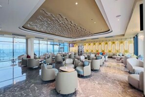 Eine geräumige Lobby mit modernen Sitzgelegenheiten und einer hohen, architektonisch ansprechenden Decke.