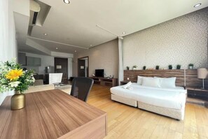 Una habitación de hotel moderna con cama, escritorio y zona de estar.