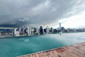 Lo skyline di una città con moderni grattacieli e una vasta distesa d'acqua che riflette gli edifici.