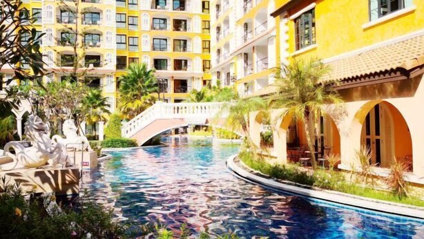 Ein Hotel mit Schwimmbecken, einer Brücke und einer weißen Statue.