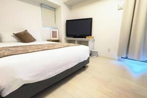 A hotel room with a large bed, a flat-screen TV, and a window with curtains. - Rakuyado Sanno (Osaka)