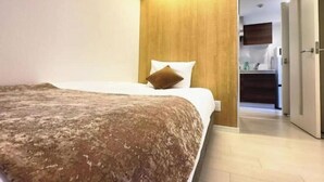 Una camera da letto con un letto, una testiera in legno, una coperta marrone e un cuscino bianco.