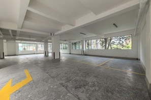 An empty parking garage with concrete floors, large windows, and visible structural beams. - Nairobi Xiaomi Hotel (Nairobi)