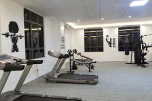 A gym with treadmills, weight machines, and a punching bag. - Nairobi Xiaomi Hotel (Nairobi)