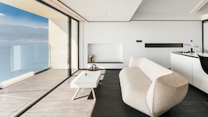 A modern interior with a sofa, a small table, and a kitchen area.