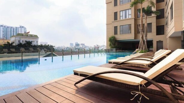 A rooftop pool area with lounge chairs and a view of the city skyline. - Saigon Royal and Tresor apartments (Ho Chi Minh City)
