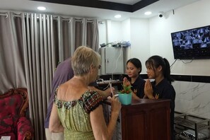 A room with a reception desk, a television mounted on the wall, and a red chair. - Suorsdei Sawadee (Kampot)