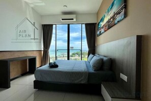 A bedroom with a large bed, a view of the ocean, and a painting on the wall. - PD D’Wharf Amazing Seaview Suite 9 (Up to 6 Pax) (Port Dickson)