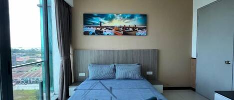 A hotel room with a large bed, a view of the city, and a painting on the wall.