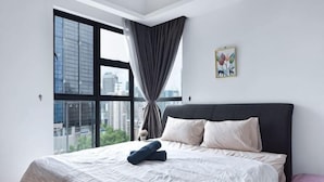 Une chambre avec une grande fenêtre, un lit et une vue sur la ville.