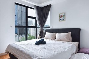 Ein Schlafzimmer mit großem Fenster, einem Bett und Blick auf die Stadt.