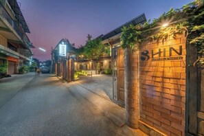 Fachada de hotel de ladrillo con señalización iluminada.