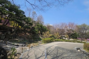 A park with a curved pathway, trees, and a building in the background. - 8 minutes away from Chungmuro Station, hill location,Breakfast for more than five nights (Seoul)