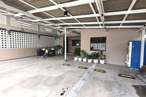 An indoor area with a concrete floor, a white ceiling with beams, a blue cabinet, and potted plants. - Relax Inn DMK (Bangkok)