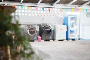 A laundromat with multiple washing machines and a self-service dryer. - Relax Inn DMK (Bangkok)