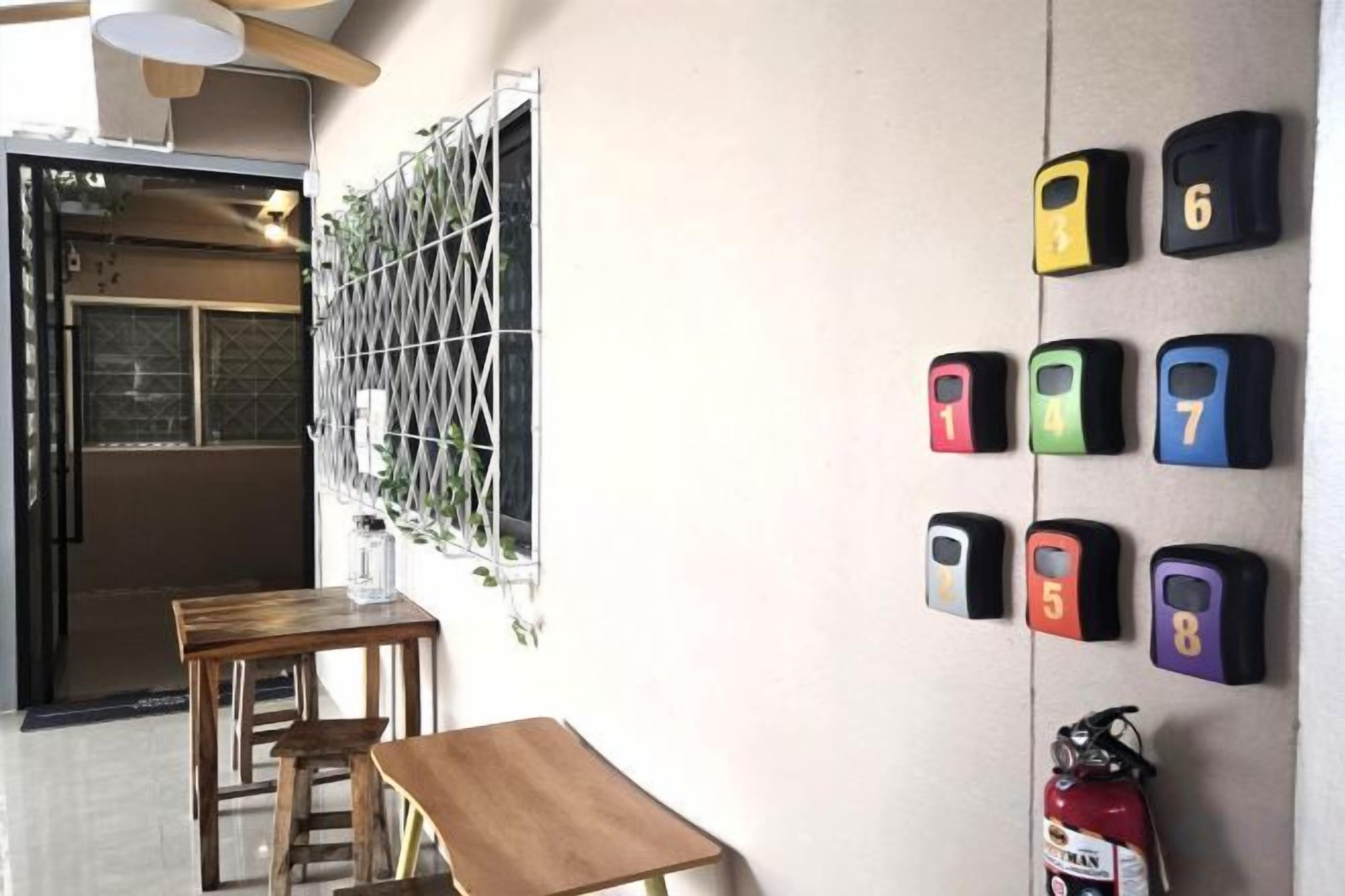 A room with a fire extinguisher, a wall-mounted number plate, and a door.