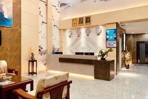A hotel lobby with a reception desk, seating area, and decorative wall elements. - Youngsun Hotel (Sihanoukville)