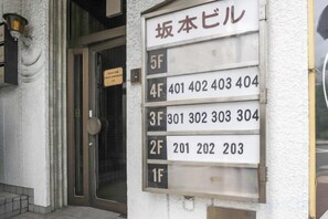 A building with a sign listing apartment numbers and names.