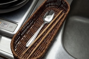 A wicker basket with a spoon and a fork on a metallic surface. - Kaike shibaura (Tokyo)